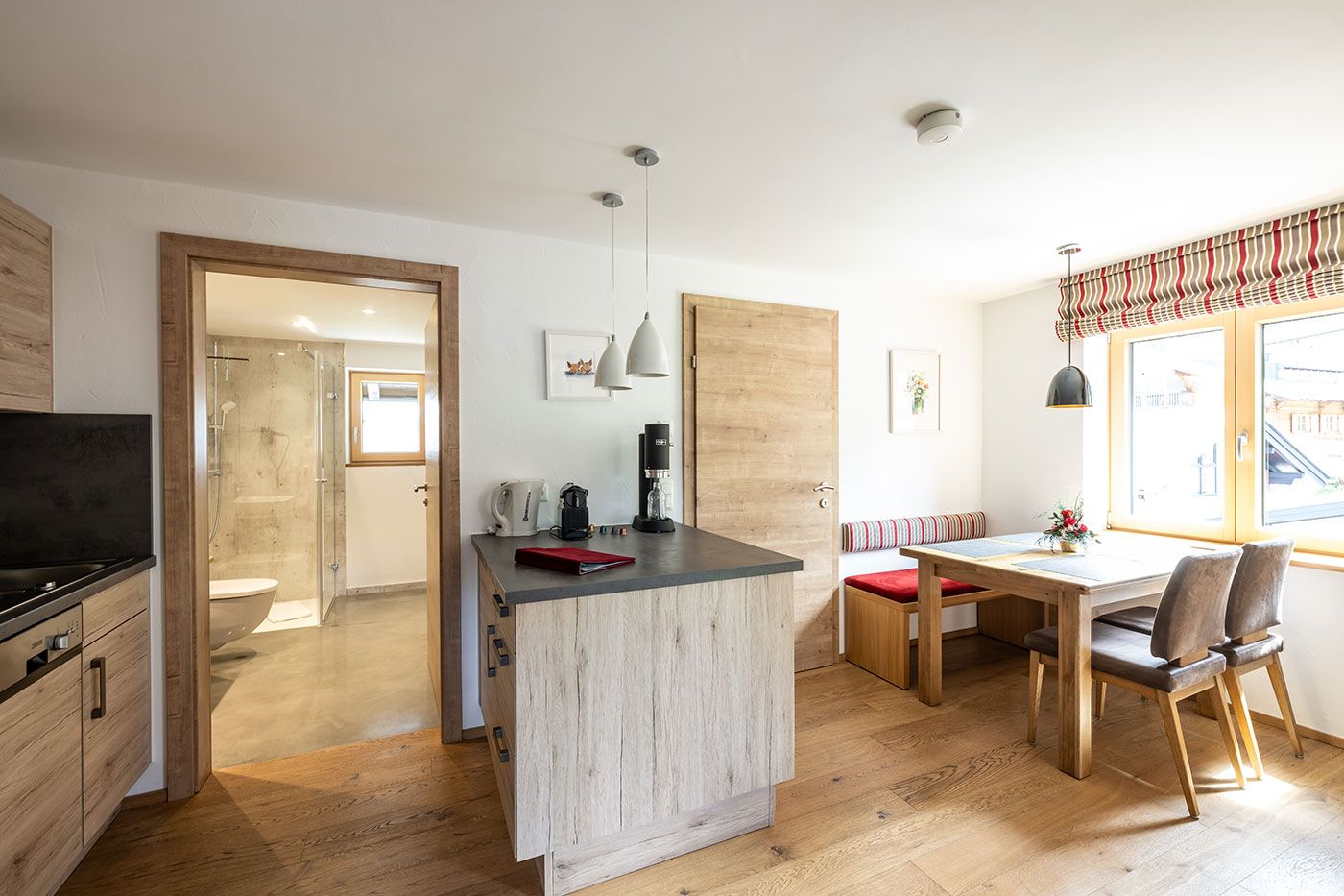 Heller Küchen- und Essbereich mit Zugang zu Bad und Schlafzimmer
