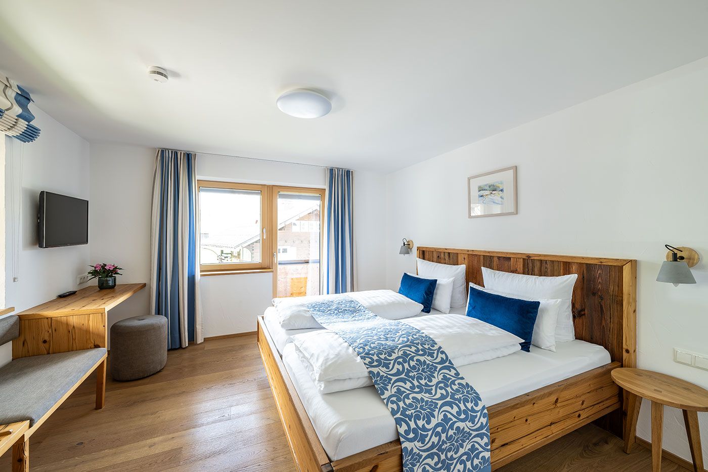 Schlafzimmer vom Apartment 1 mit Doppelbett, Balkonzugang, Kofferablage und TV