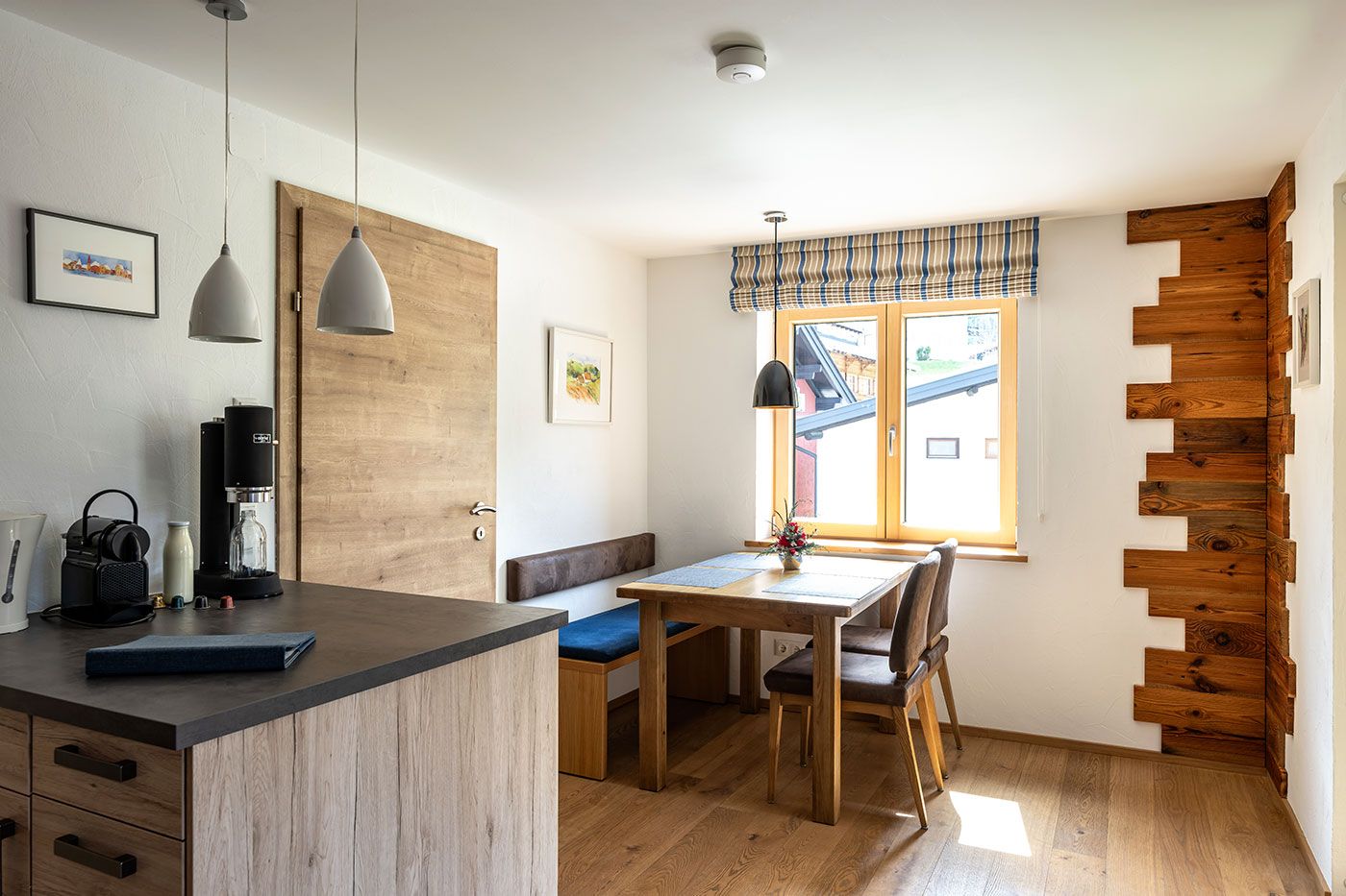 Küchenzeile und Esstisch des Apartments 1 mit Bank und 2 Stühlen sowie Fenster