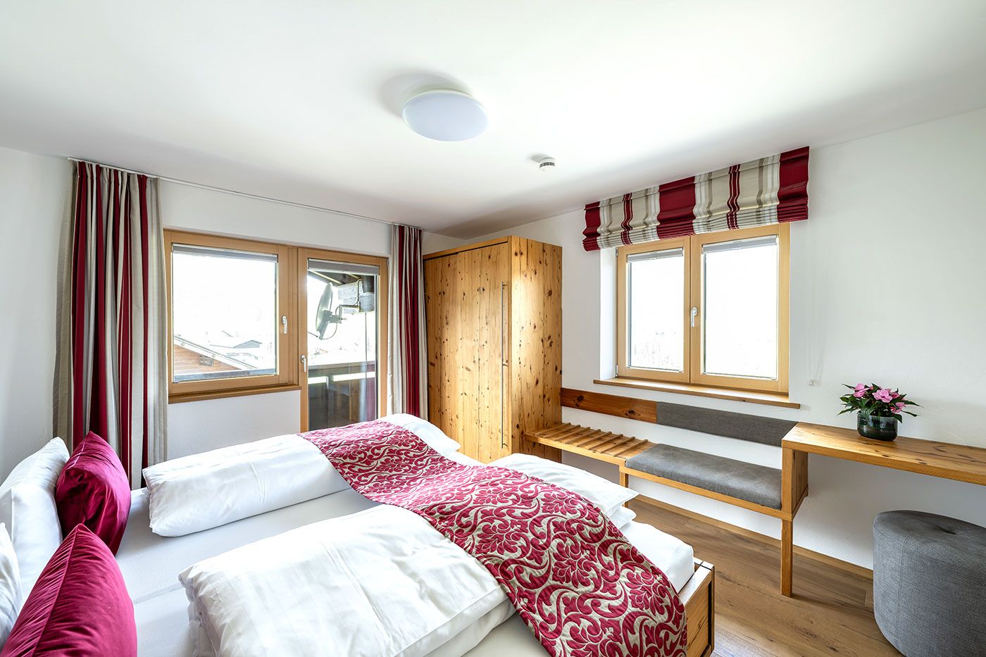 Schlafzimmer mit Doppelbett, Balkonzugang, Schrank, Vorhängen und Kofferablage