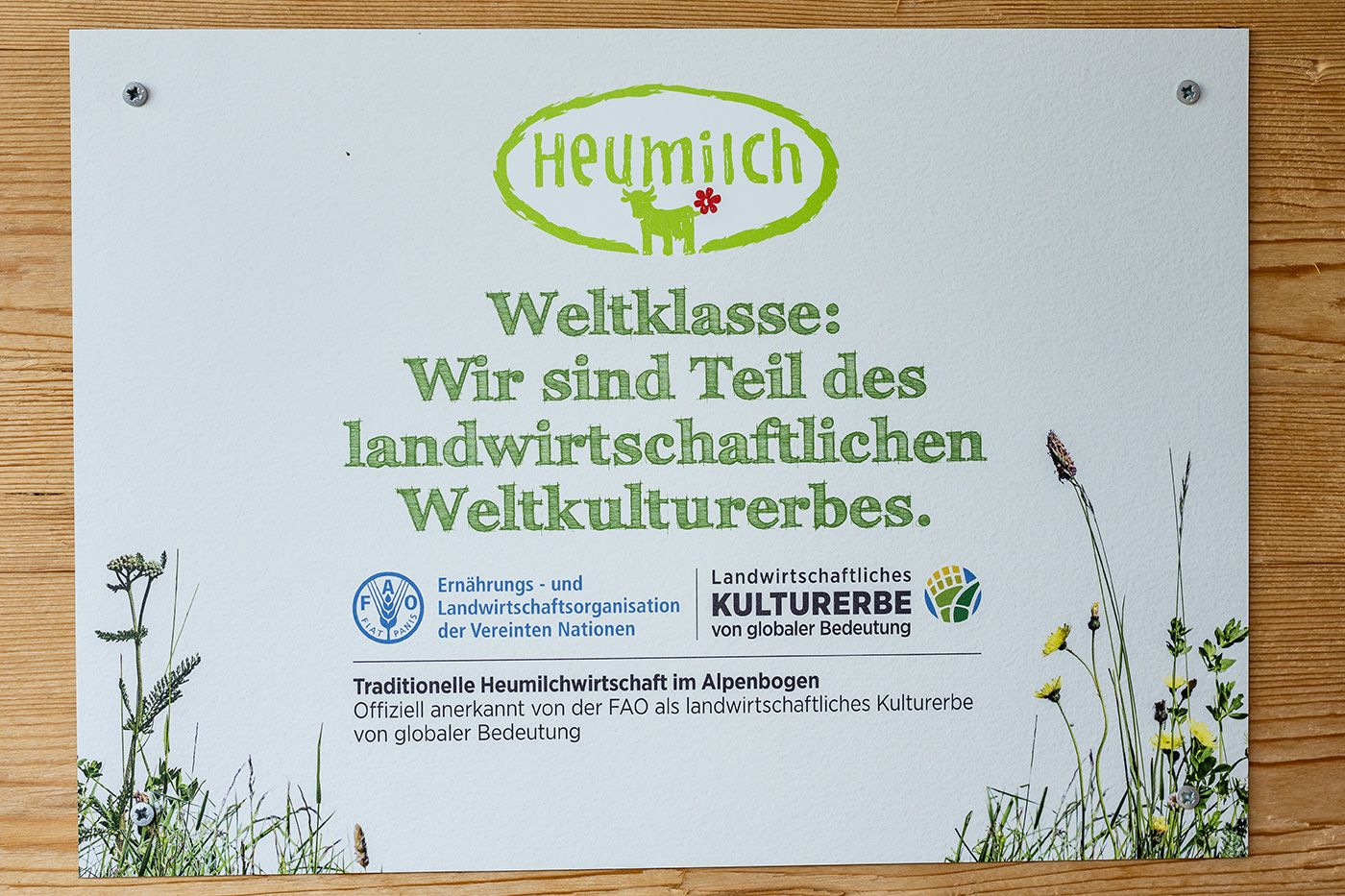 Heumilch Schild "Weltklasse: Wir sind Teil des landwirtschaftlichen Weltkulturerbes"