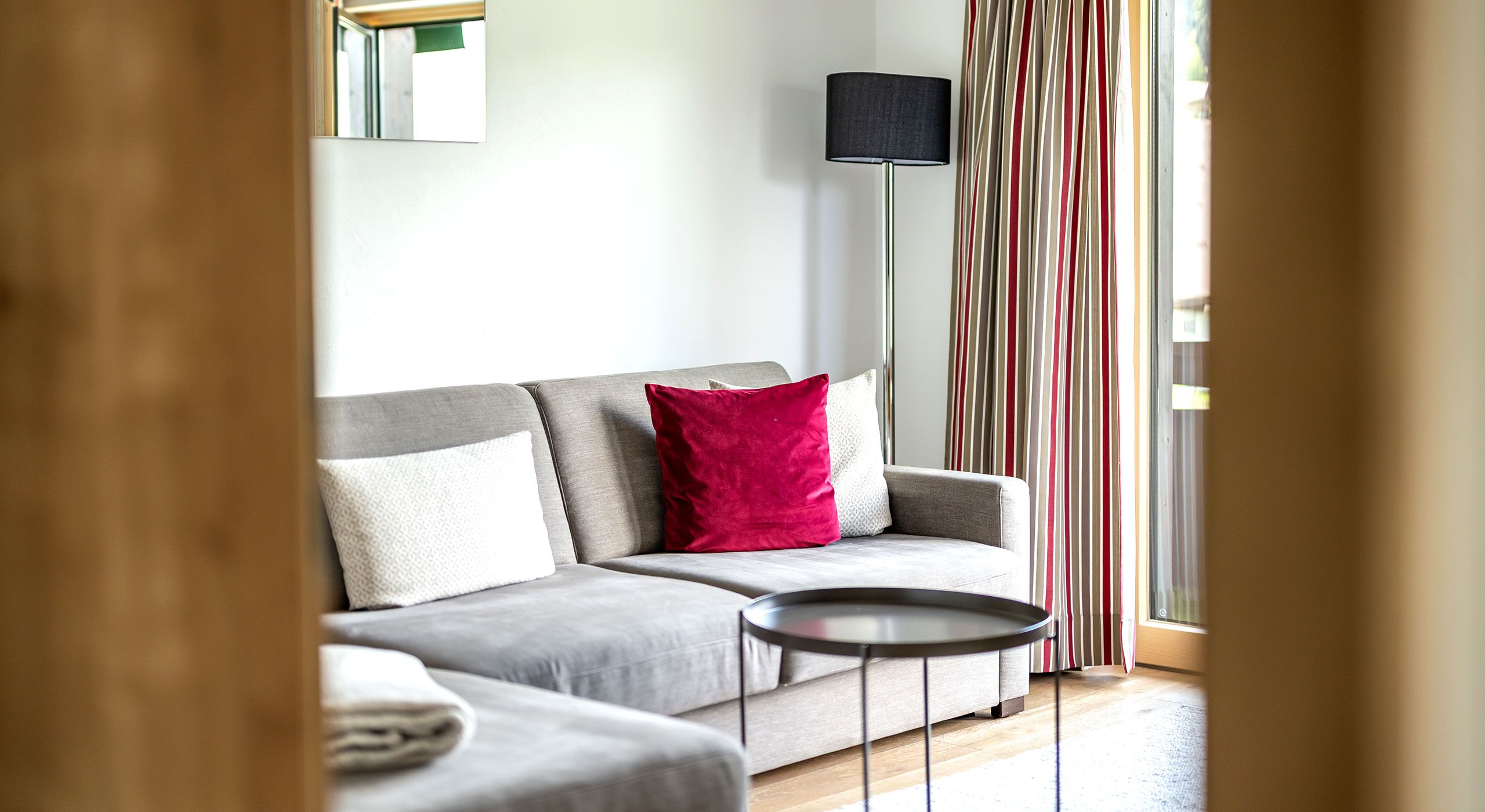 Blick ins Wohnzimmer Apartment 4 auf den Ottomanen