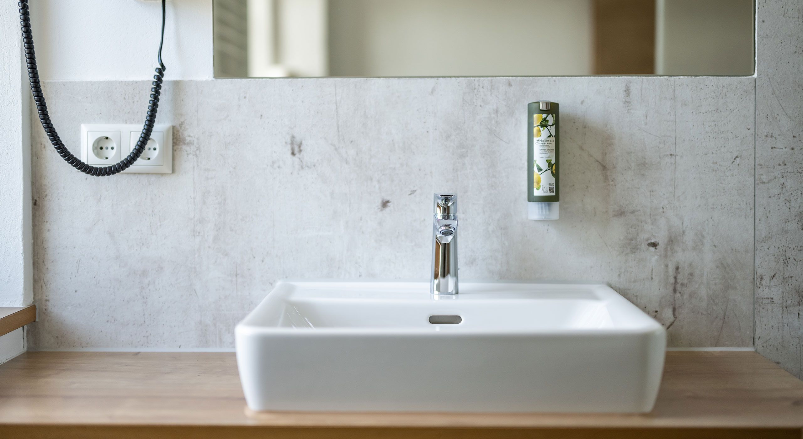 Waschbecken mit Seifenspender, Spiegel und Fön