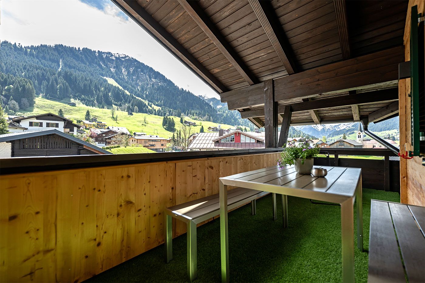 Aussicht vom Balkon auf die Berge mit Tisch und Bänken